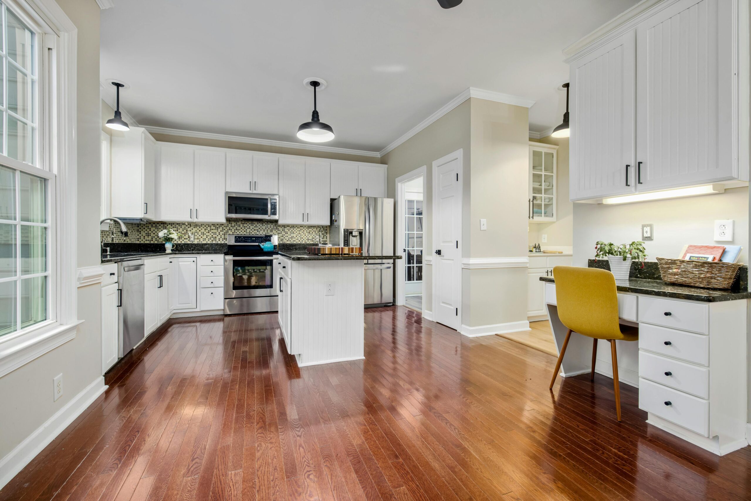Spacious contemporary kitchen with wooden flooring and modern design elements. Ideal for home decor inspiration.